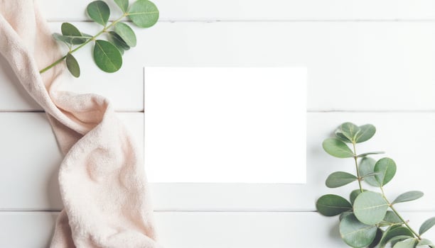Blank paper on white wooden background with eucalyptus leaves photo