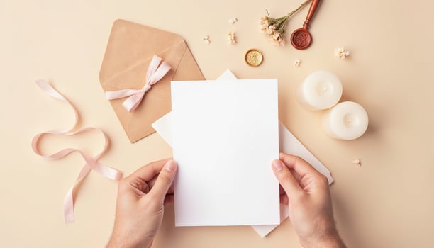 Hands holding blank paper and envelopes with candles and flowers photo