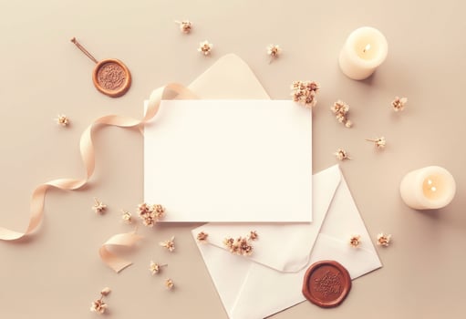 A blank card, envelope and candles on a beige background photo