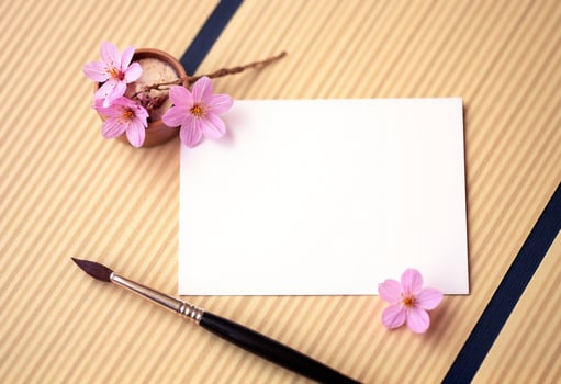 A blank note card and a brush on a wooden table photo