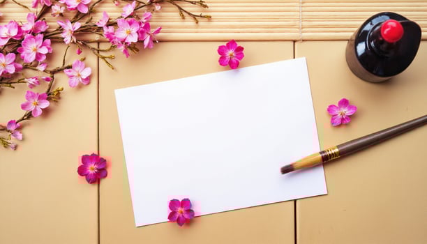 A blank paper, ink pen and flowers on a wooden table photo