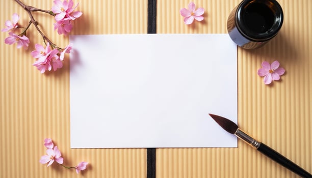 A blank paper, ink pen and a cherry blossom branch on a wooden background photo