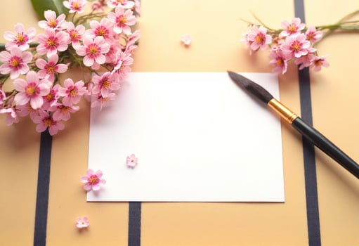 A note with a pen and flowers on a yellow background photo