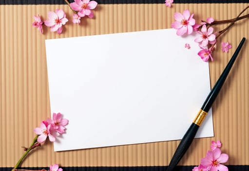 A blank paper and a pen on a brown paper background with cherry blossom photo