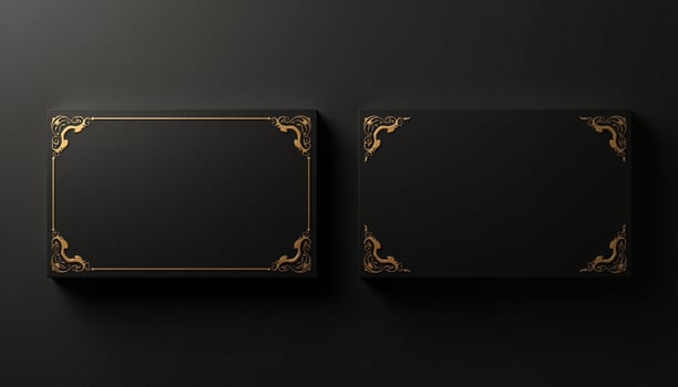 Two black square boxes with gold trim on a black background photo