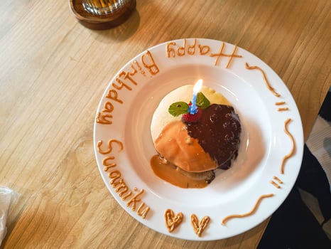 Celebratory Pancake Cake with Candle on White Plate with Birthday Message photo
