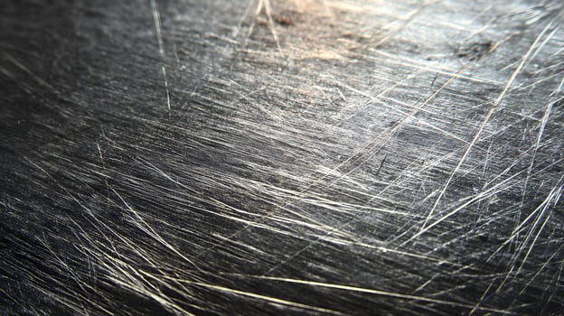 Distressed metallic surface with random scratches offering a gritty texture and industrial appeal photo
