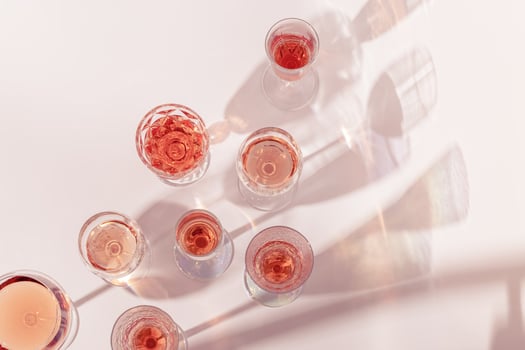 Rose wine assortment in crystal glasses, rose champagne sparkling wine with daylight shadows. Summer alcoholic drink photo