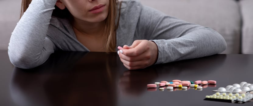 Hopeless young woman with depression planning to commit suicide by overdosing on meds at home. Desperate lady having nervous breakdown, feeling stressed, going through existential crisis photo