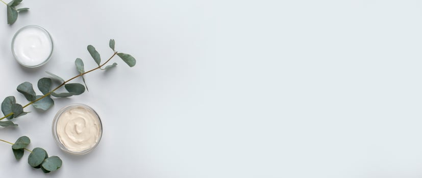 Natural body care products. Eco friendly homemade cream for face and skin on gray background, panorama, copy space photo