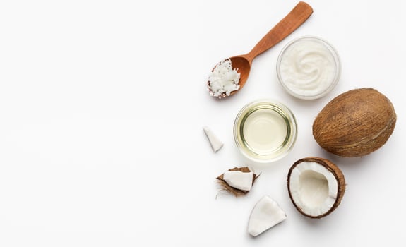 Fresh coconut and coco oil on white background top view, copy space. Vegetable fats concept photo