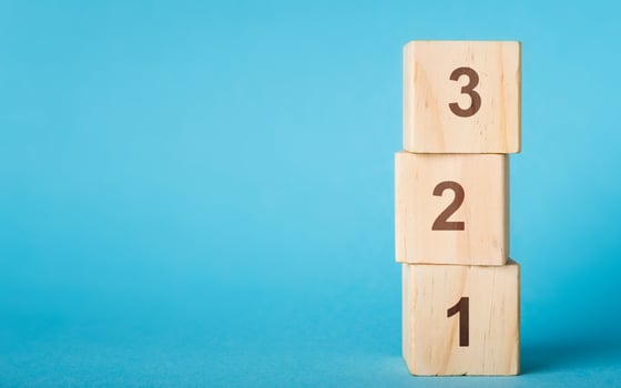Wooden alphabet number blocks 123 on blue background, copy space photo
