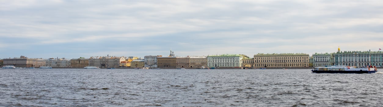 View of Historic Buildings Along the Neva River in St. Petersburg During a Cloudy Day With Boats in the Foreground photo