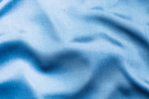 Silky blue fabric draped to showcase smooth texture and color depth photo