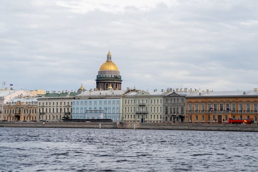 Stunning View of St. Petersburgs Historic Waterfront With the Iconic Dome of St. Isaacs Cathedral Shining Under Cloudy Skies photo