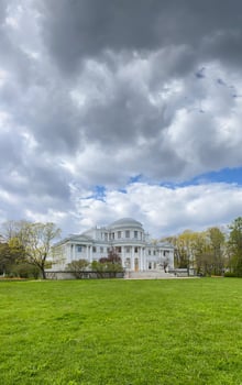 Historic Mansion Surrounded by Lush Green Landscape Under Dramatic Skies in Springtime photo