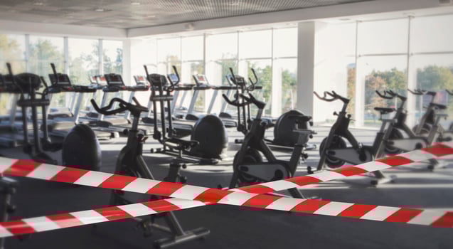 Quarantine Zone Warning Tape, Do Not Cross. Red and white hazard safety stripes across empty closed gym club center photo