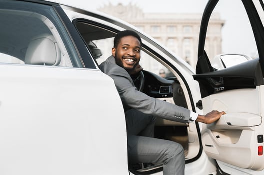 Car Rental. African American Businessman Opening Automobile Door Getting Out Of Auto In City. photo