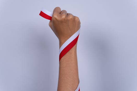 Hand Fist Holding a Red and White Ribbon, Indonesian Independence Day Concept and Hands Clenched photo