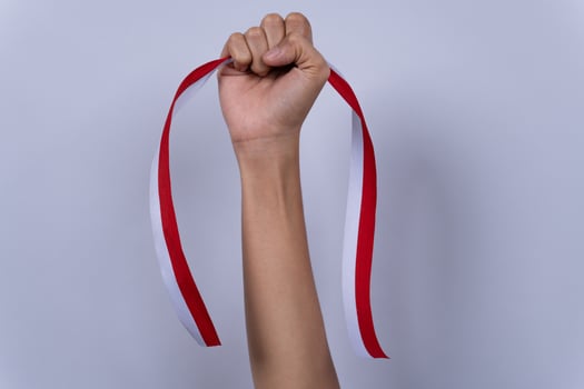 Hand Fist Holding a Red and White Ribbon, Indonesian Independence Day Concept Isolated Background photo