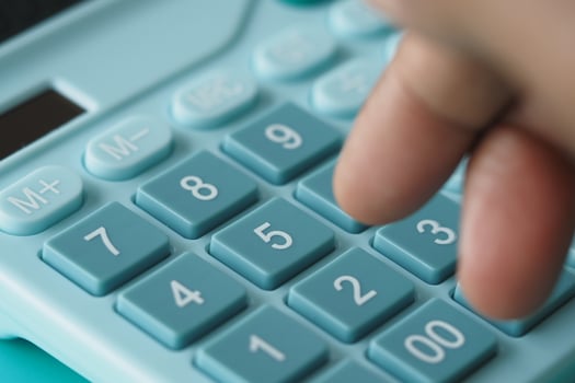 Pressing buttons on a teal calculator photo