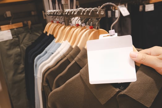 Blank tag on Minimalist T Shirt Display in Clothing Store, Neatly Folded Apparel on shirt Shelves. Blank for text. photo