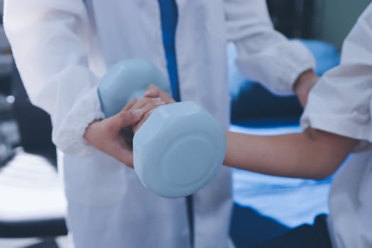 A doctor holding a blue dumbbell in his hand photo