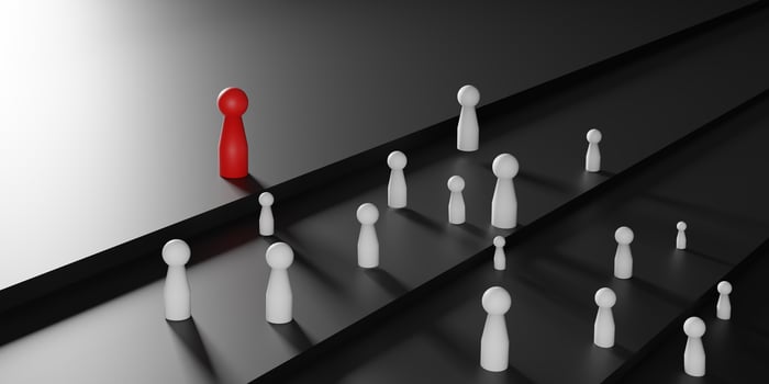 Red doll stands out among white doll on black stairs, symbolizing leadership, individuality, and success. 3D render highlights contrast and hierarchy for strong visual impact and conceptual clarity. photo