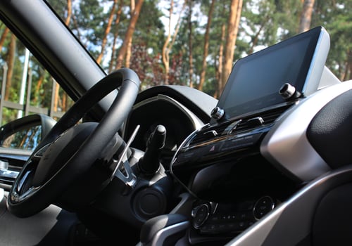 Bottom view of steering wheel and central dashboard of car parked in forest photo