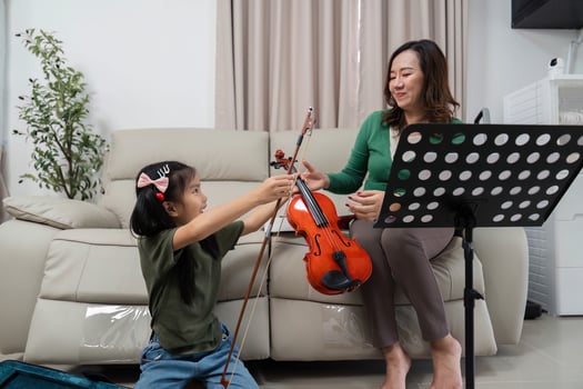 Musical Bonding. Mother and daughter sharing a moment with a violin during practice. photo