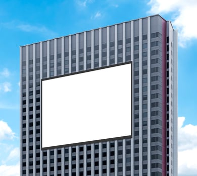 Mockup white horizontal large LED display billboard on tower building with blue sky background .clipping path for mockup photo