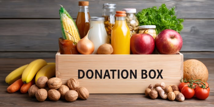 Donation box full of fresh food on wooden table.. photo