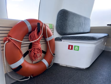 Safety equipment inside electric passenger boat including lifebuoy and seating with fire extinguisher and life jacket icons. Clean modern interior for public water transport. photo