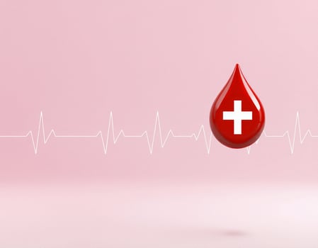 A red blood drop is floating in front of a heartbeat line photo
