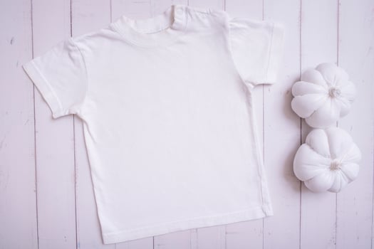 White children's t-shirt mockup for logo, text or design on wooden background with pumpkins top view photo