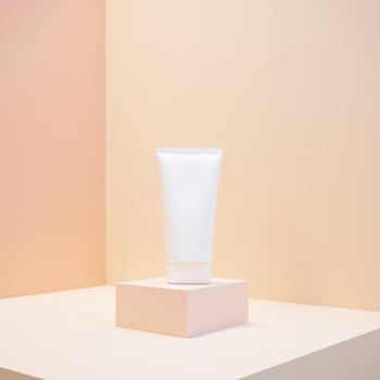 A tube of cream on a stand in front of a pink wall photo