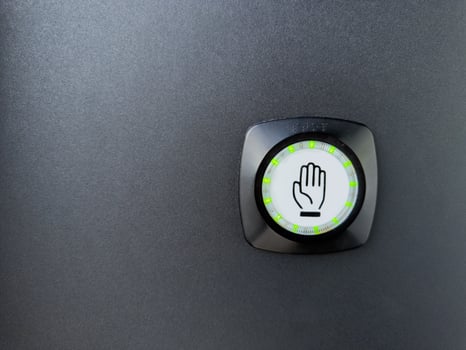 Closeup of touch sensitive button with hand icon and green LED indicators on a black surface. Modern design element often used for contactless door activation or access systems photo
