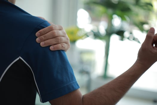 a man with a shoulder injury in a blue shirt photo