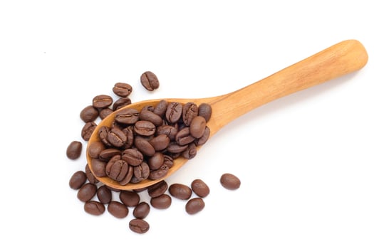 Coffee beans in spoon, brown roasted coffee beans in wooden spoon on white background. photo