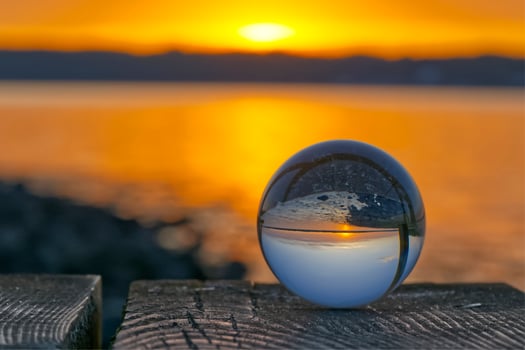 A Glass ball reflects early summer sunset in Solituede near Flensburg in beautiful golden colors photo