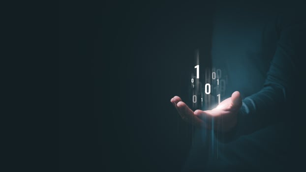 A man's hand shows an abstract virtual binary code hologram to symbolize the unification of control and encryption, protecting against cyber attacks. photo