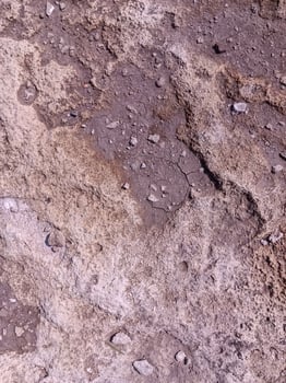 A rocky surface with a few small rocks scattered about. The surface is rough and uneven, with some areas appearing to be more worn down than others. Scene is somewhat desolate and rugged photo