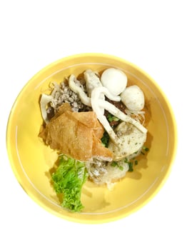 Top view of Spicy TOM YAM fish ball noodle with lemongrass, chilly pasted and lime juice, focus selective photo