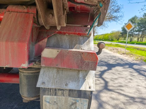 A dirty truck. The truck is parked on a road with a yellow sign in the background photo