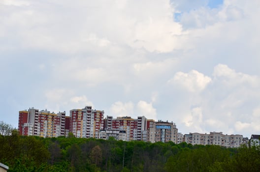 A city skyline with a large red building in the middle. The sky is cloudy and the buildings are tall photo