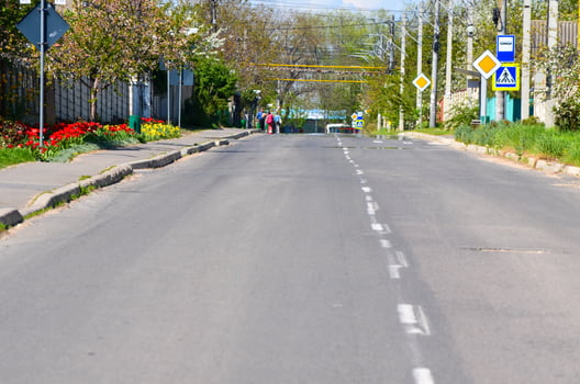 A street in the village where there are road signs in front. The sign Bus stop, pedestrian crossing and main road. photo