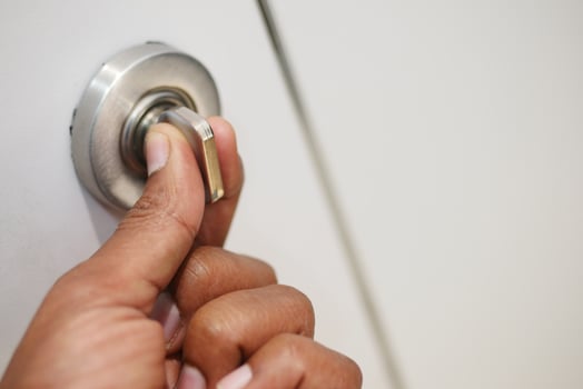 Hand turning door knob to open a white door photo