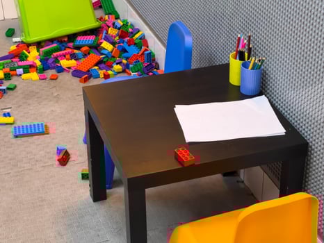 Children are engaged in creative play with colorful plastic building blocks around a small table in a cozy room photo