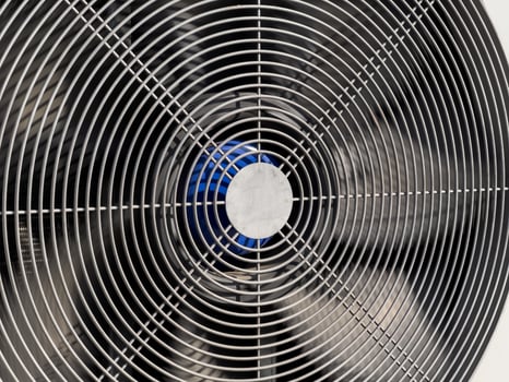 A detailed view of a large industrial fan showcasing metallic lines and a vibrant blue center, typical in modern ventilation systems photo