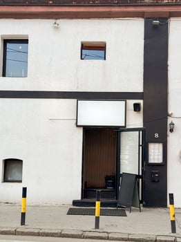 Minimalist restaurant entrance with blank signboard and black-and-white facade. Modern urban design in European street setting photo